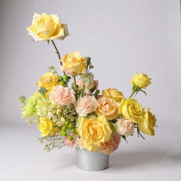 sun-kissed garden yellow and peach floral arrangement in ceramic vase