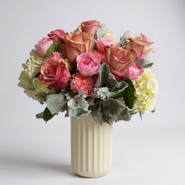 blushing grace flower arrangement with roses, hydrangeas, and dusty miller in ivory vase