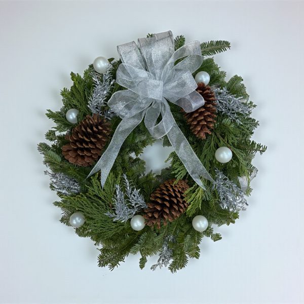 Winter wreath with silver bow, frosted greenery, large pinecones, and pearl ornaments
