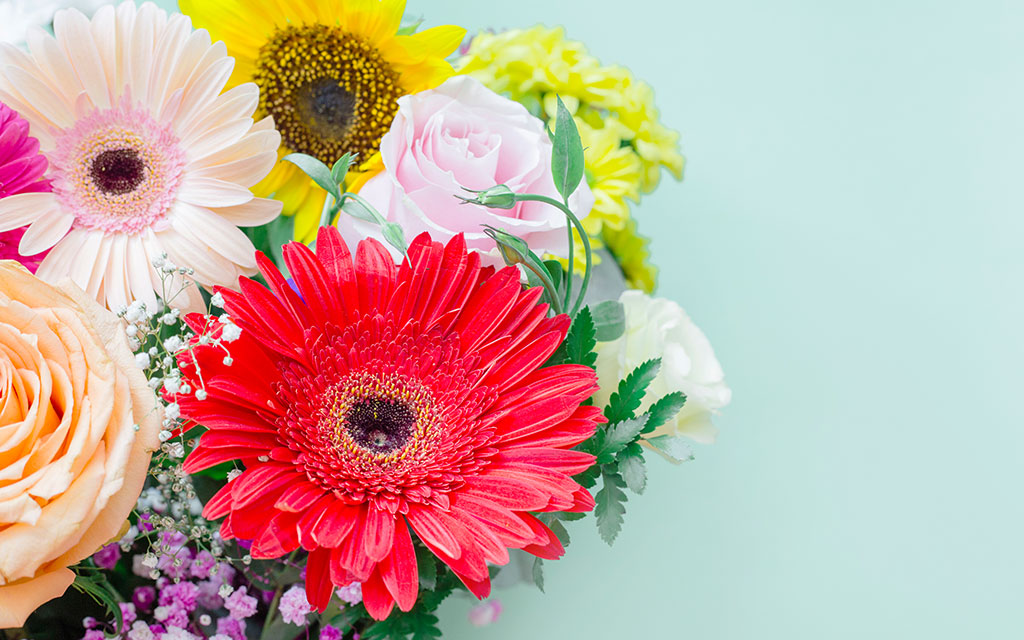 Bright cheerful Valentine's bouquet with gerbera daisies, sunflowers, and pink roses for joyful gifting