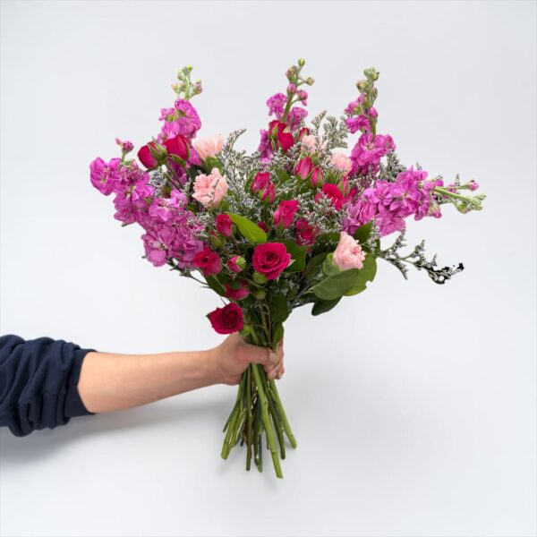 Pink stock bouquet with hot pink spray roses, blush carnations, delicate filler flower, and fresh greenery hand-tied by Quinn Florist