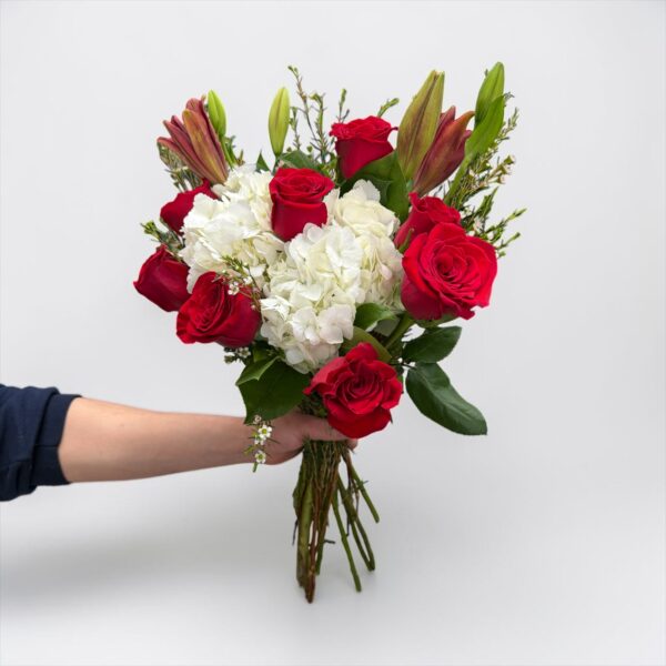Red rose bouquet with white hydrangeas, lilies, waxflower, and fresh greenery hand-tied by Quinn Florist